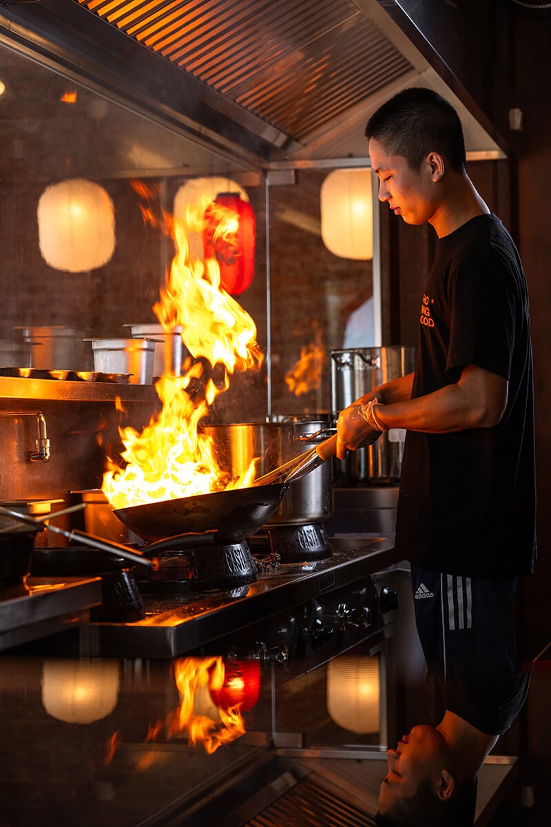 PHO KING kuchár pripravuje jedlo na plameni